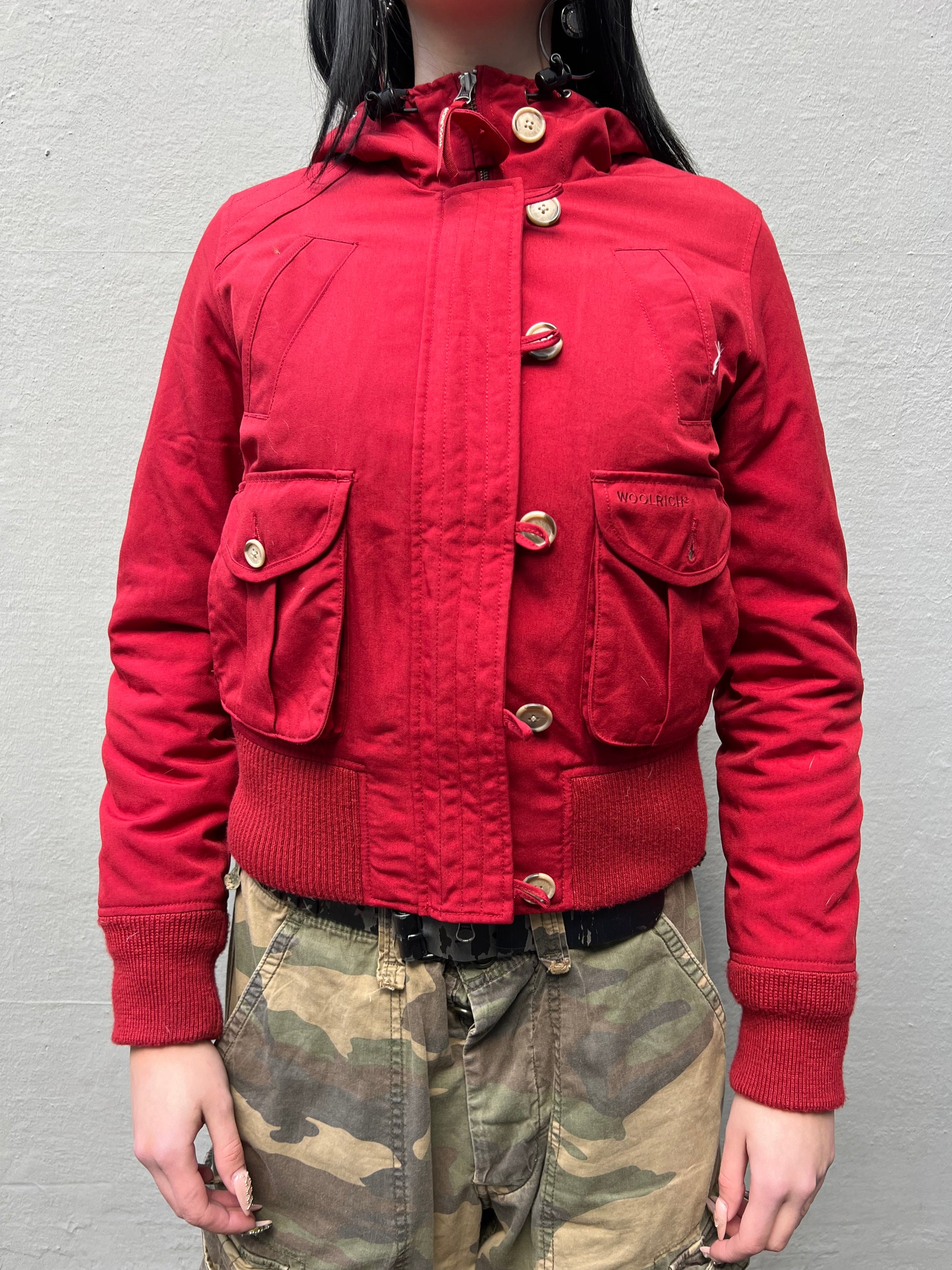 Zu sehen ist eine rote cropped Jacke von Woolrich