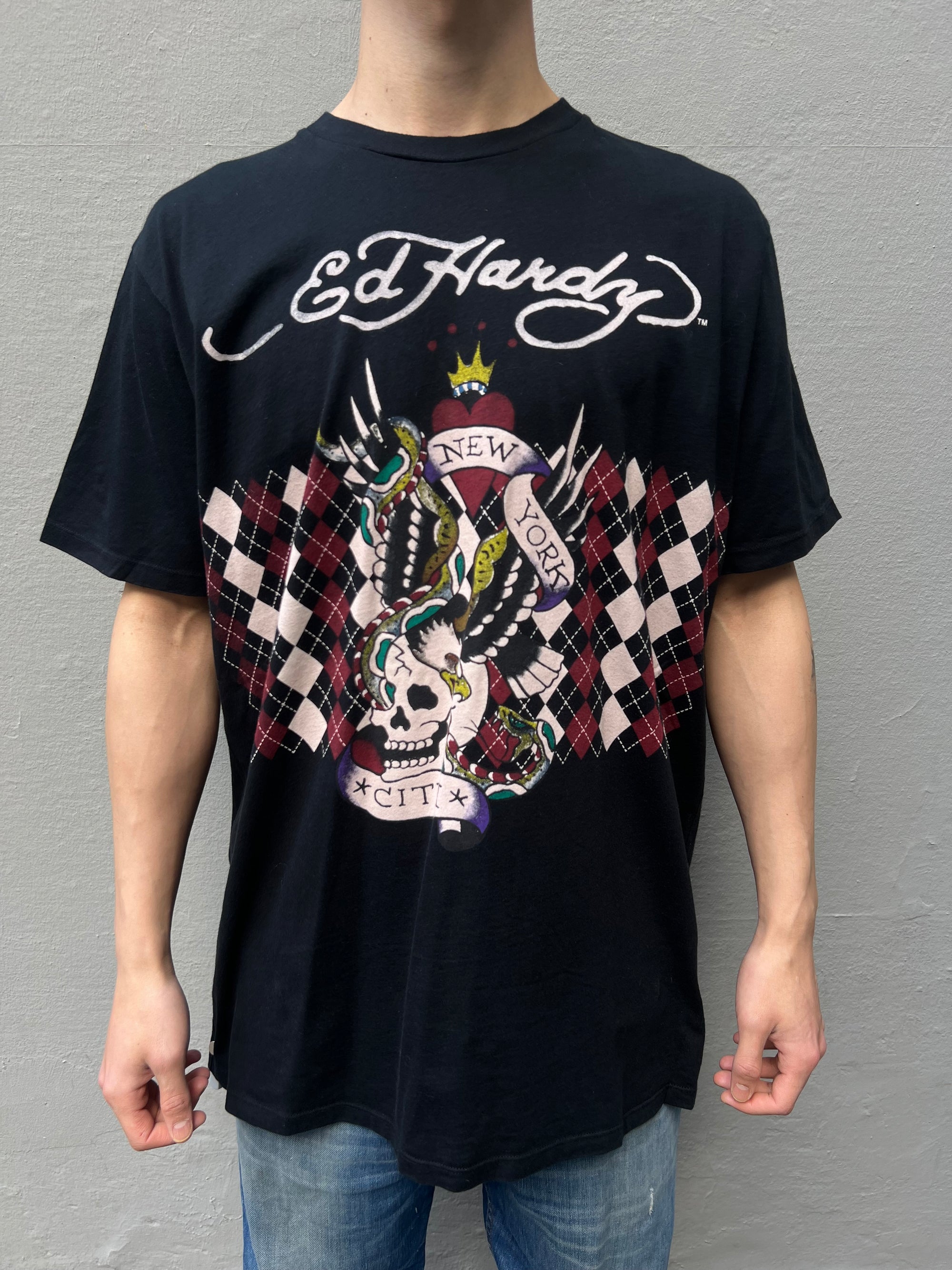 Zu sehen ist ein schwarzes Ed Hardy T-Shirt mit New York City Aufdruck und rotem Design 