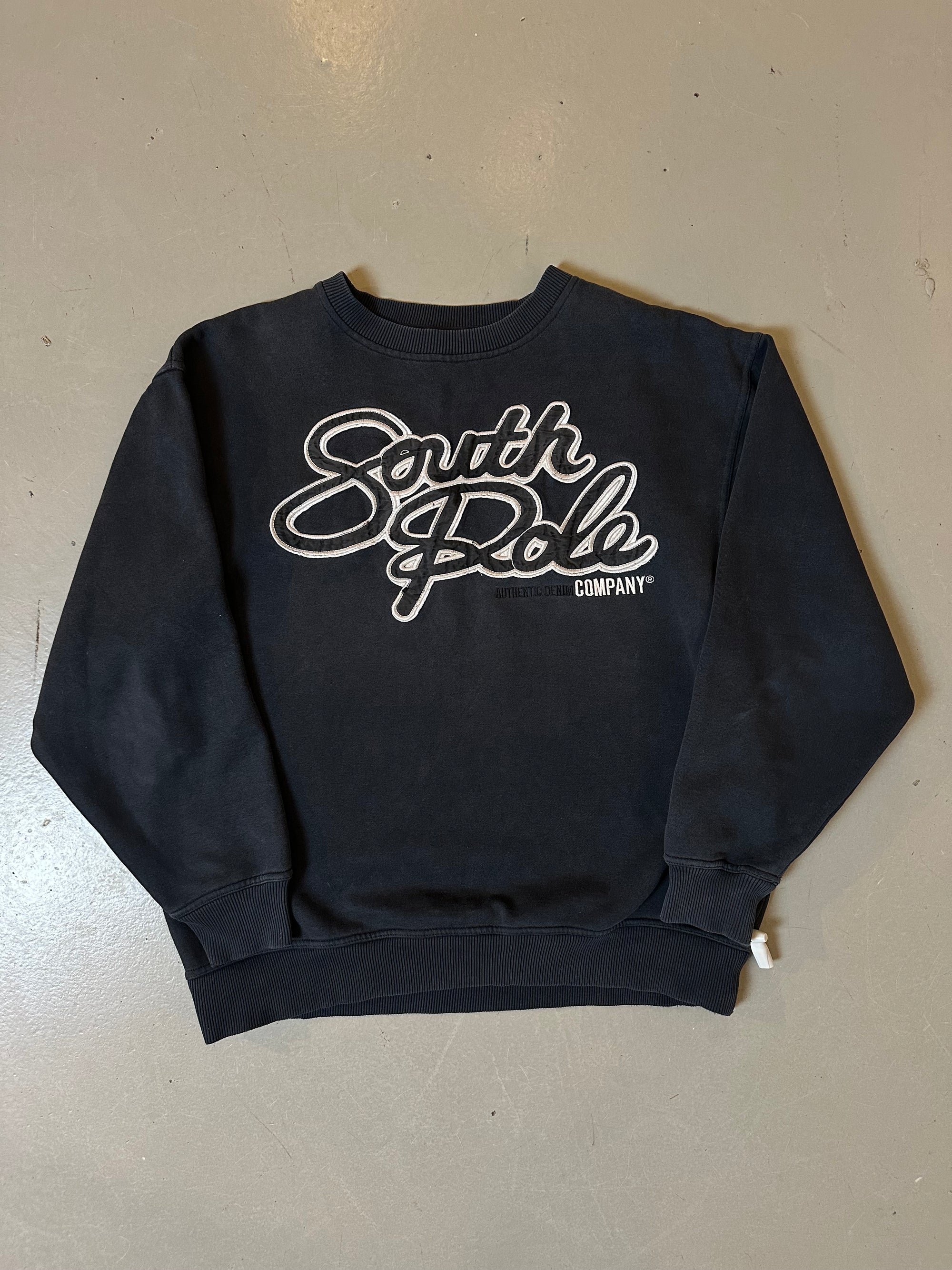 Zu sehen ist ein schwarzer crewneck sweater mit dem Southpole Logo auf der Brust 