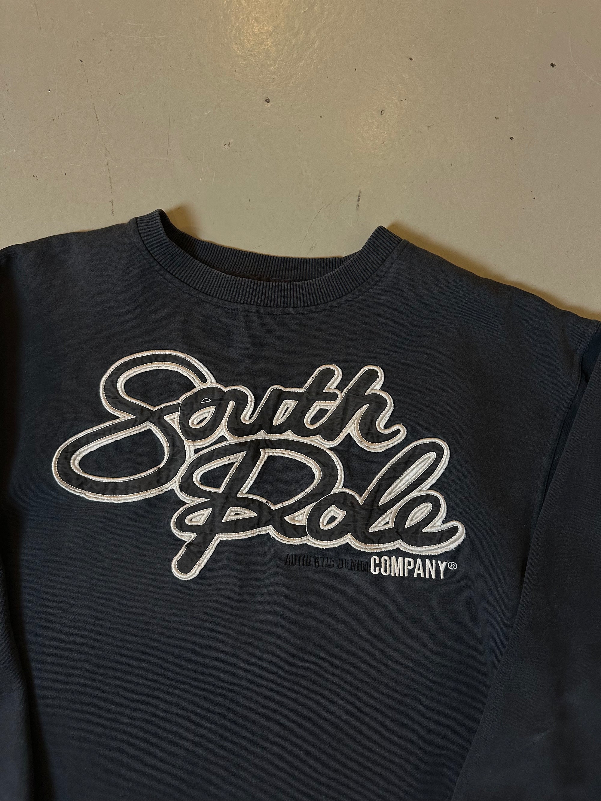 Zu sehen ist ein schwarzer crewneck sweater mit dem Southpole Logo auf der Brust 