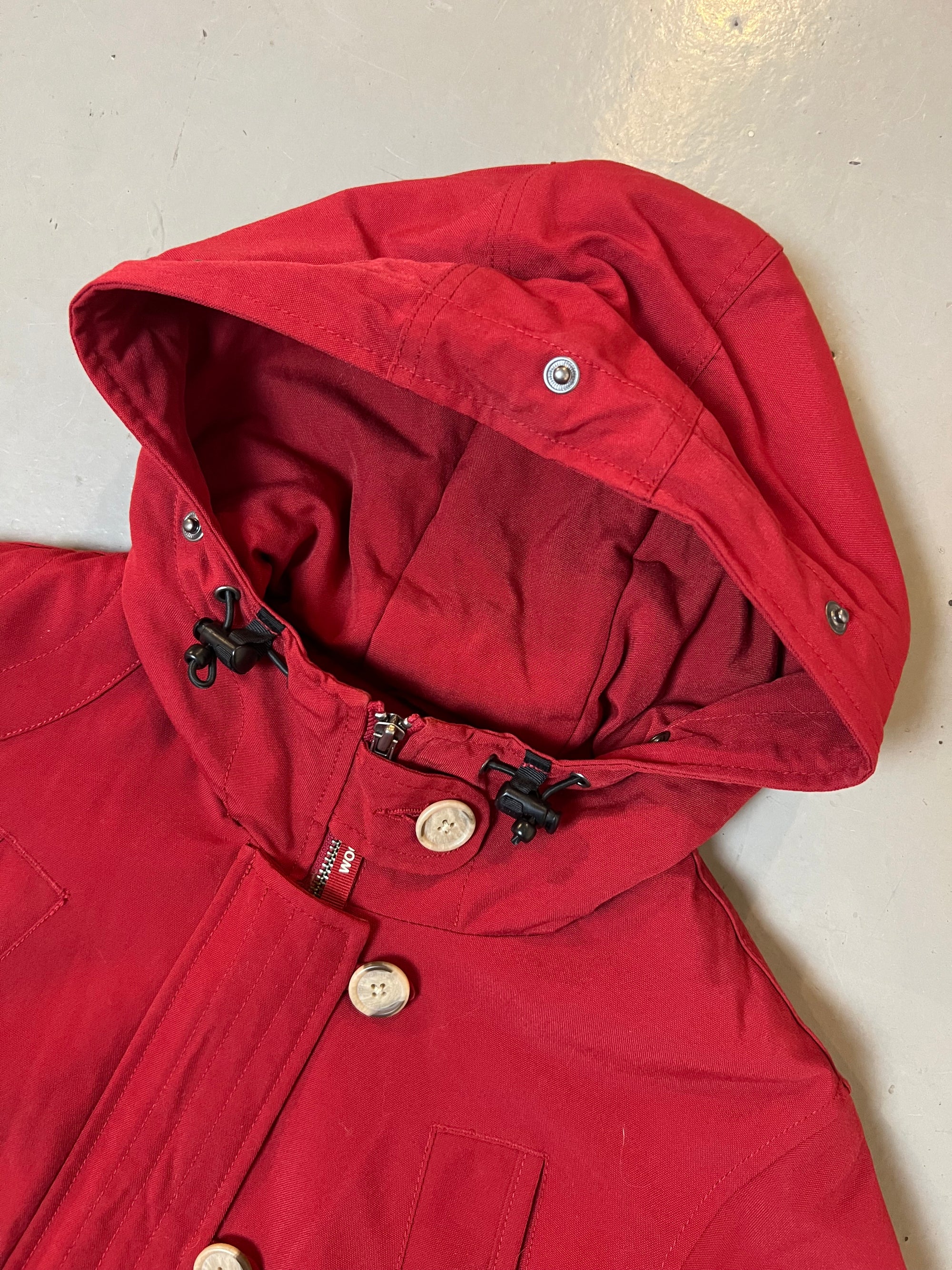 Zu sehen ist eine rote cropped Jacke von Woolrich