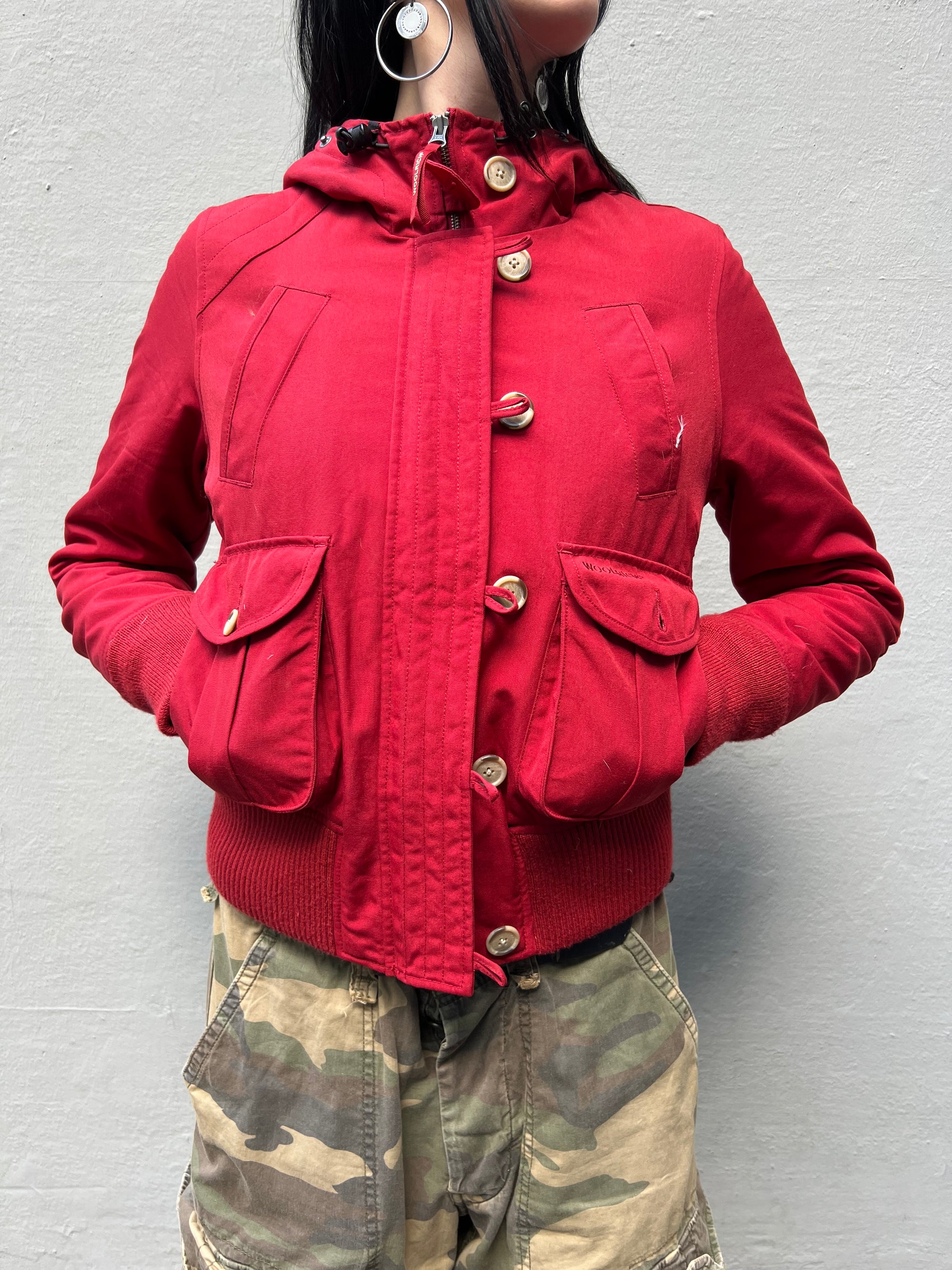 Zu sehen ist eine rote cropped Jacke von Woolrich