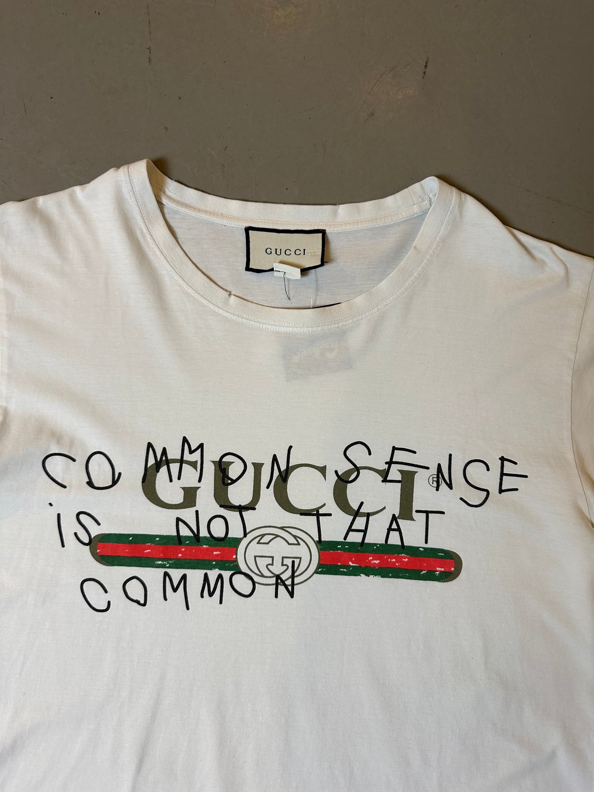 Zu sehen ist Wein weißes Tshirt von Gucci mit dem Gucci Logo auf der Brust in M/L