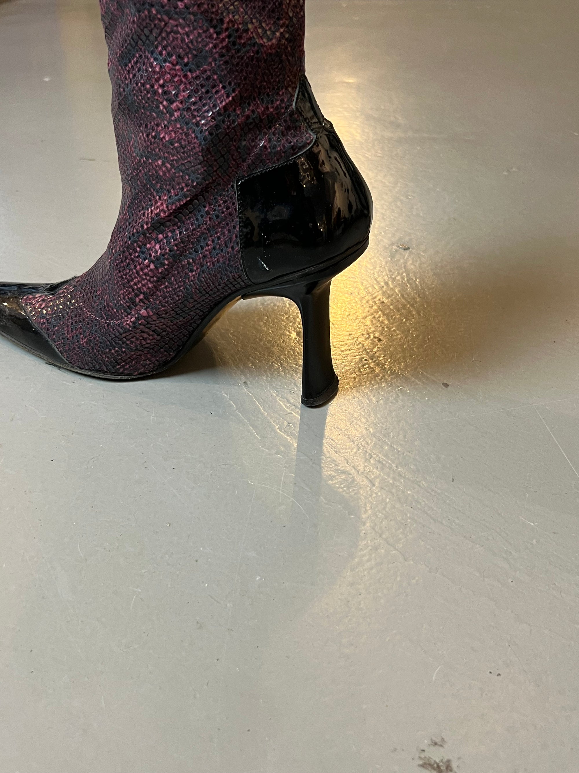 Zu sehen ist ein Lila Vintage Snake Heel vor einem grauen Hintergrund.