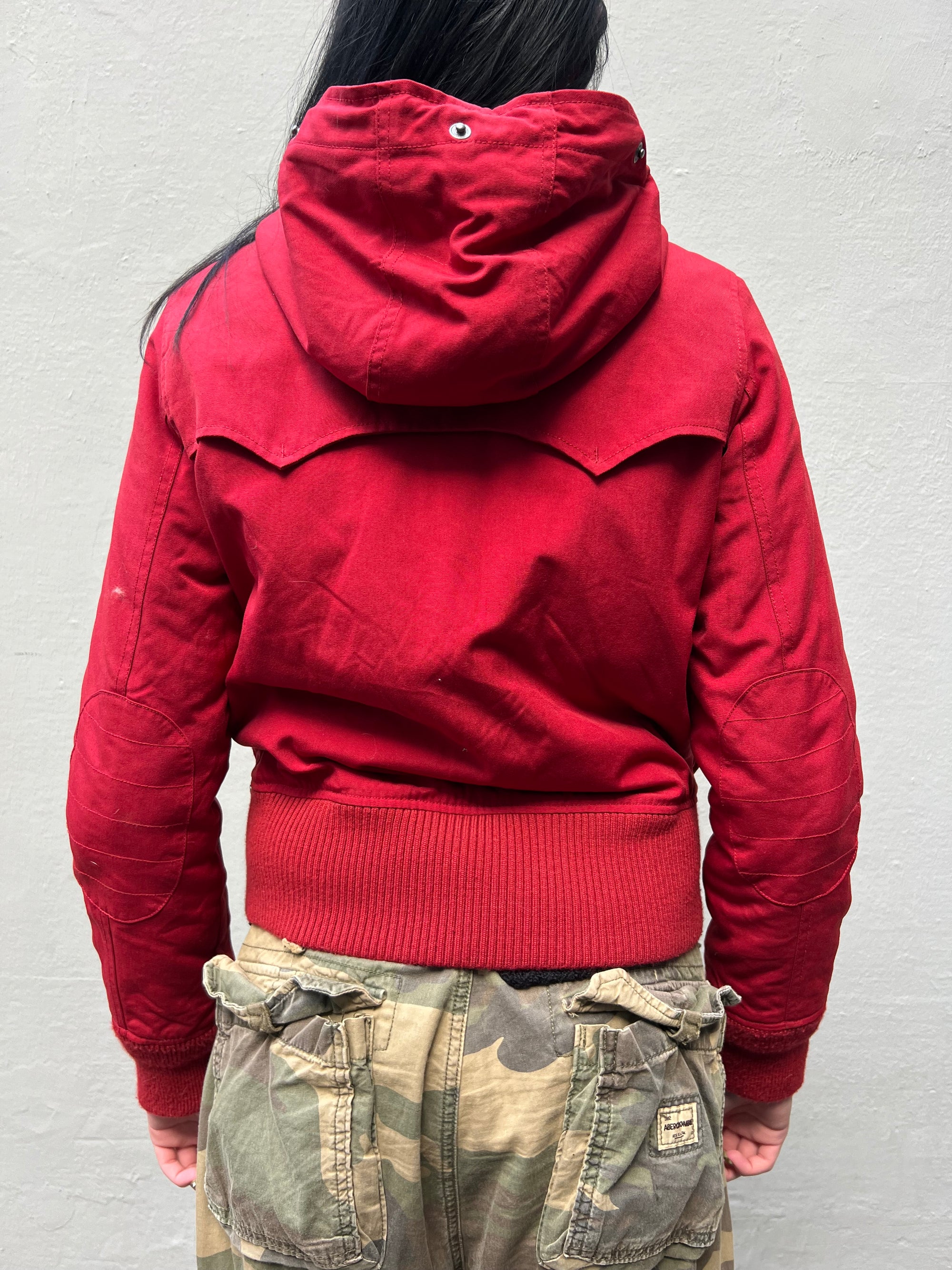 Zu sehen ist eine rote cropped Jacke von Woolrich