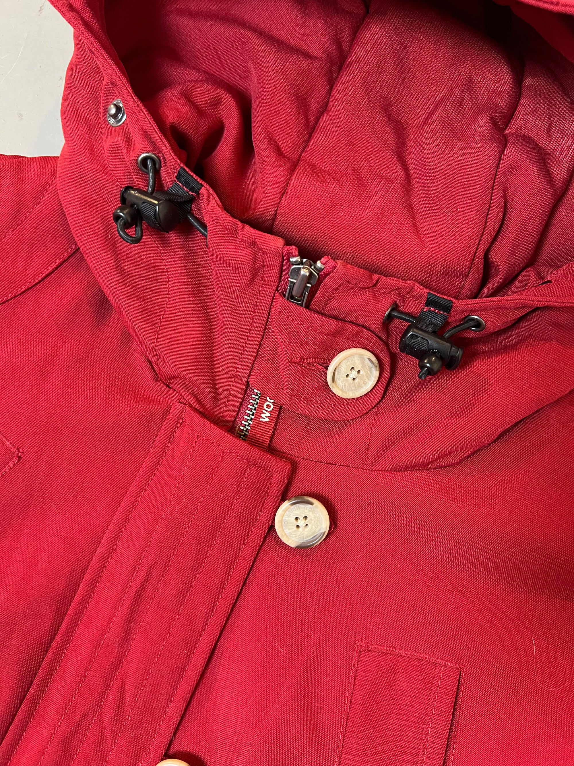 Zu sehen ist eine rote cropped Jacke von Woolrich