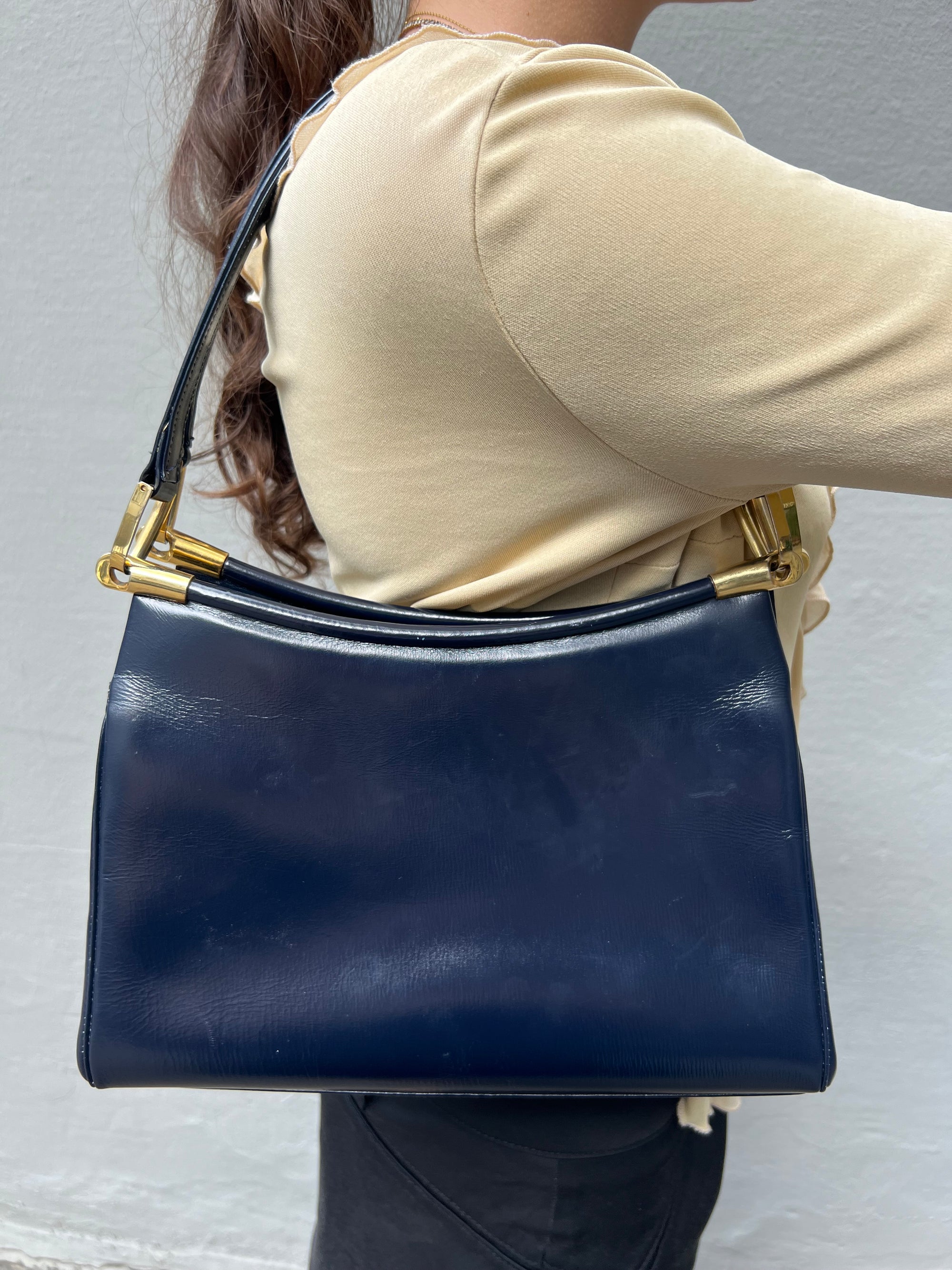 Zu sehen ist eine dunkelblaue Handtasche im Business Look