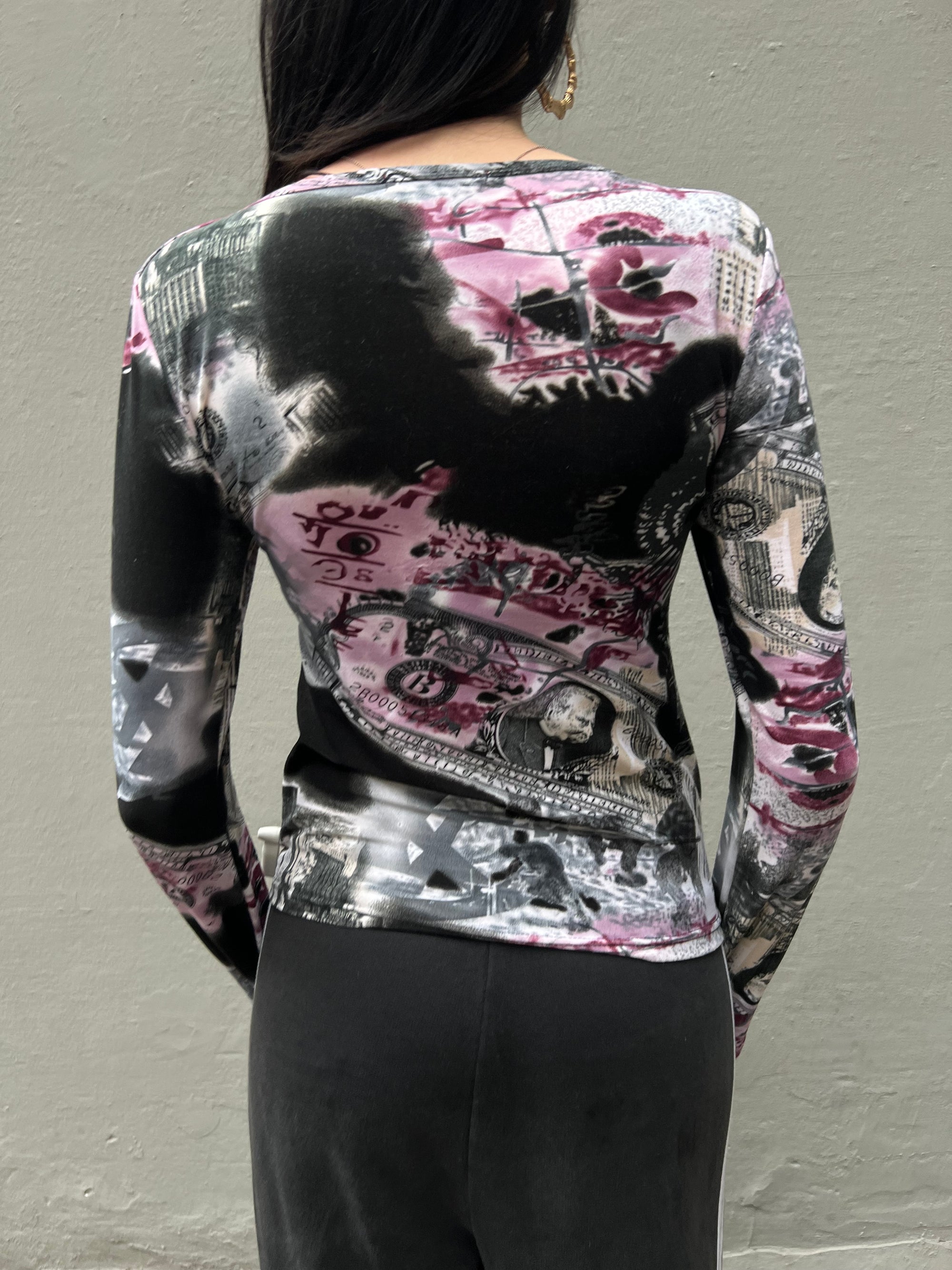 Zu sehen ist ein Longsleeve mit Schwarz Pinken Design mit Wolkenkratzern und Dollar-scheinen in S/M.