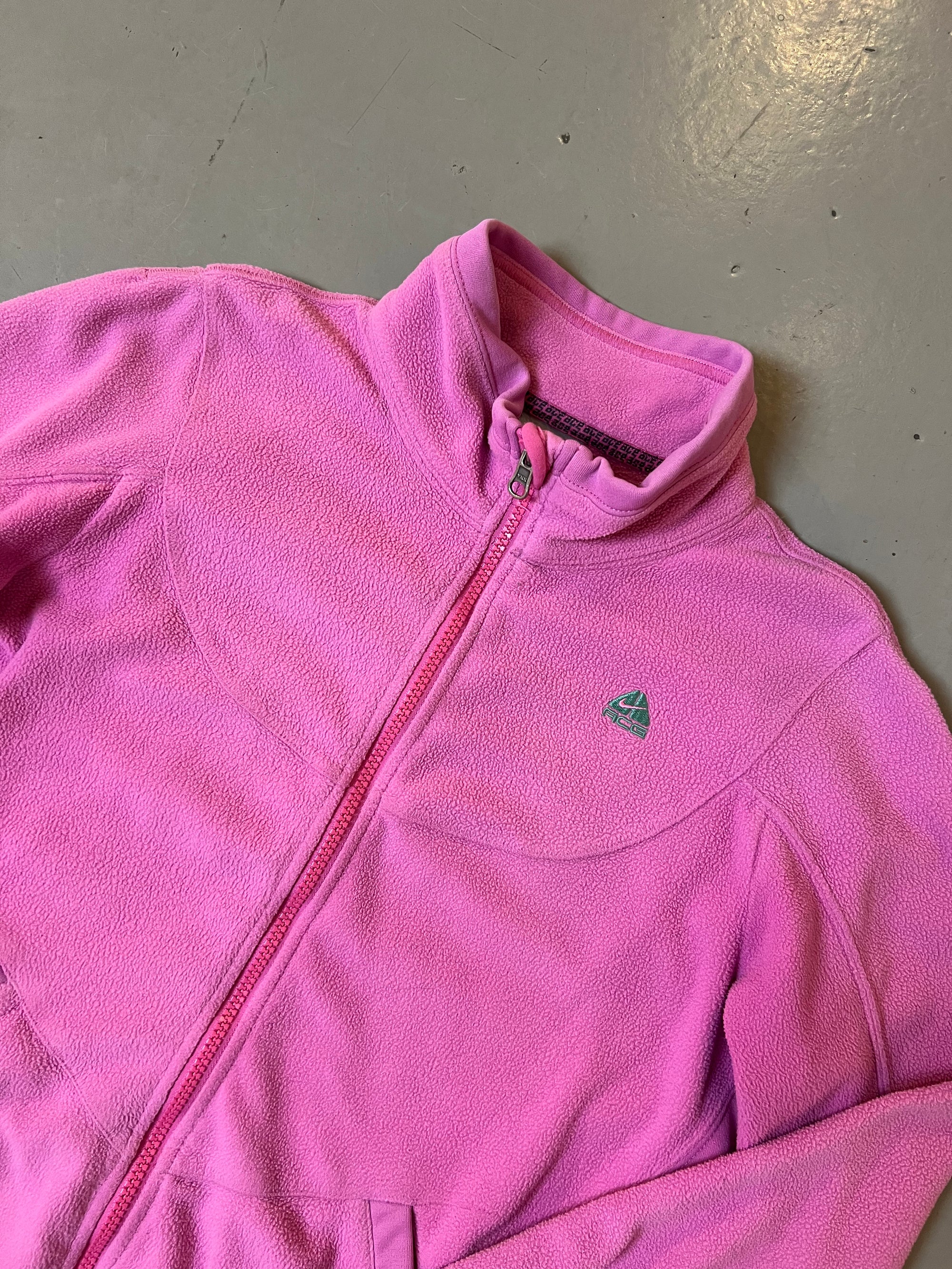 Zu sehen ist eine Pinke Fleece Jacke von Nike ACG