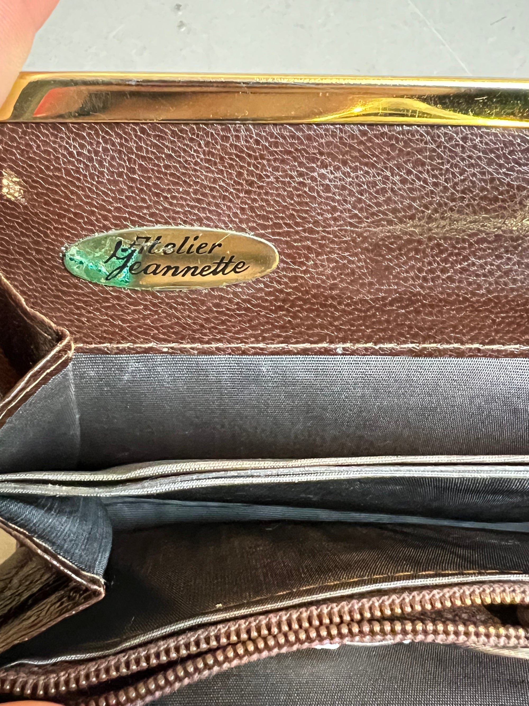 Zu sehen ist eine braune Vintage Leder Tasche vor einem grauen Hintergrund