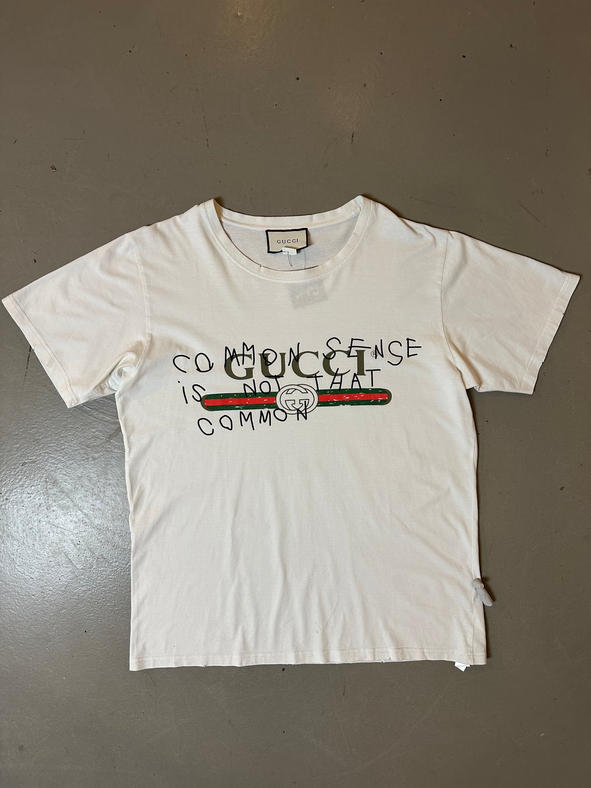 Zu sehen ist Wein weißes Tshirt von Gucci mit dem Gucci Logo auf der Brust in M/L