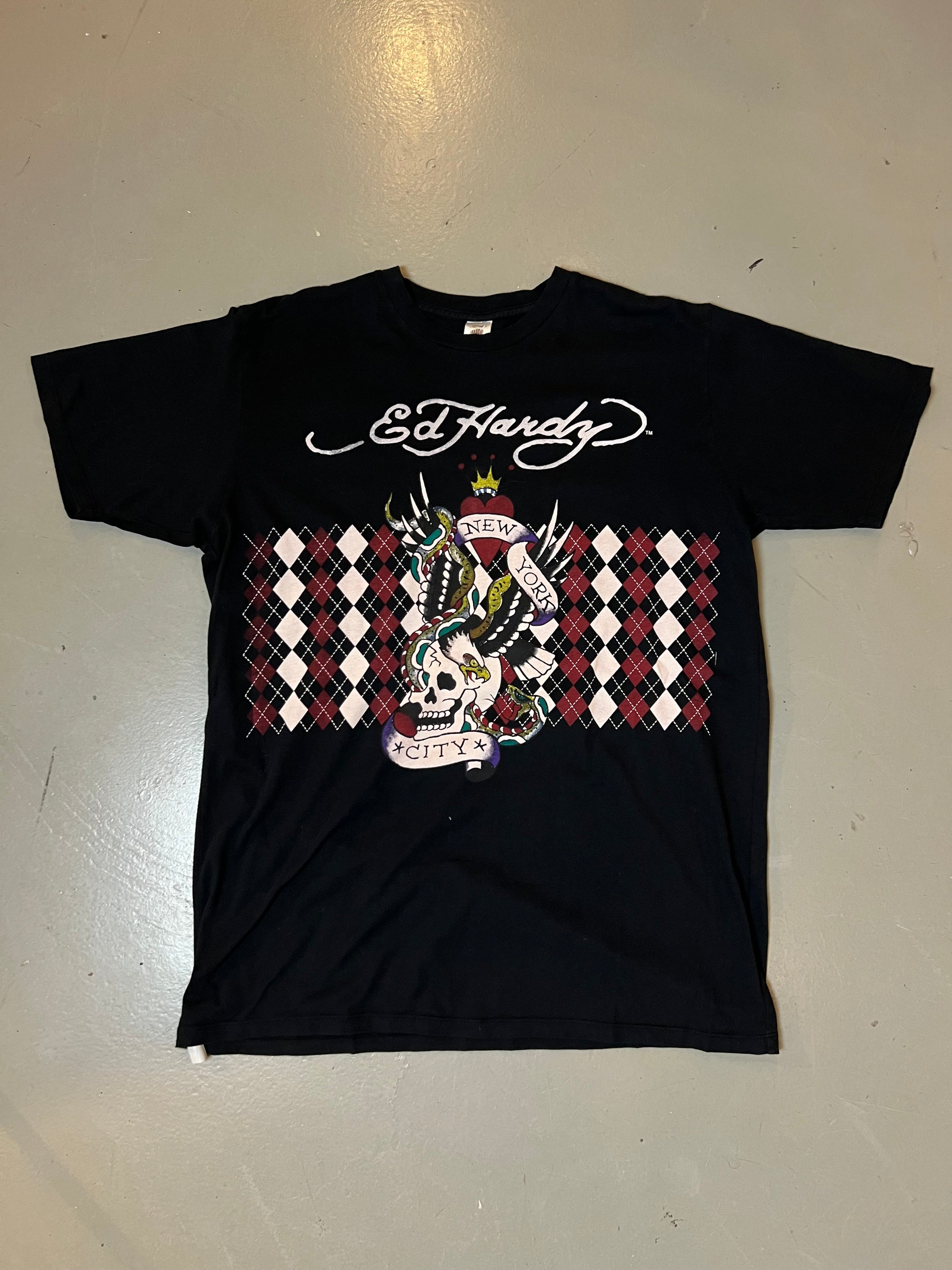 Zu sehen ist ein schwarzes Ed Hardy T-Shirt mit New York City Aufdruck und rotem Design 