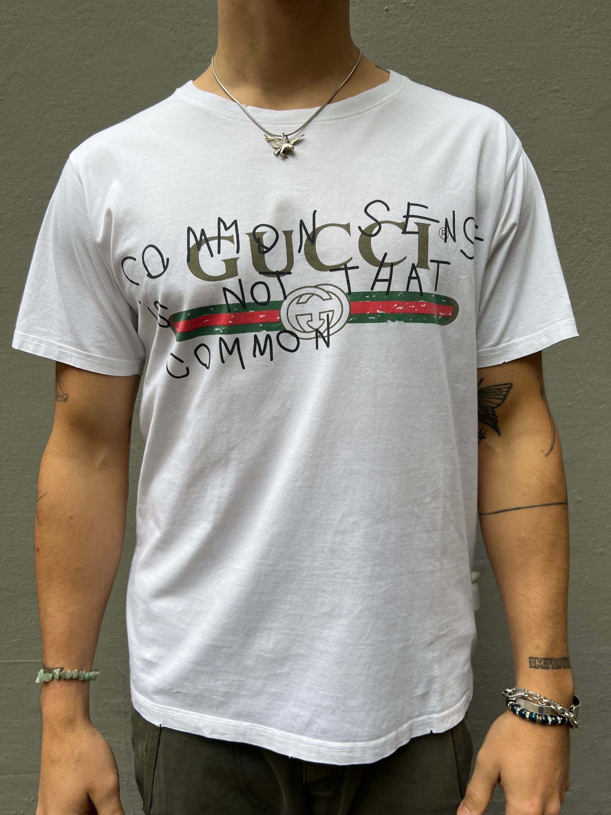 Zu sehen ist Wein weißes Tshirt von Gucci mit dem Gucci Logo auf der Brust in M/L